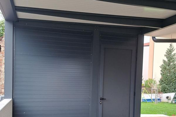 Antracit pergola Misteral na terasi, ki nudi moderno zaščito pred vremenskimi vplivi in izboljša zunanji ambient.